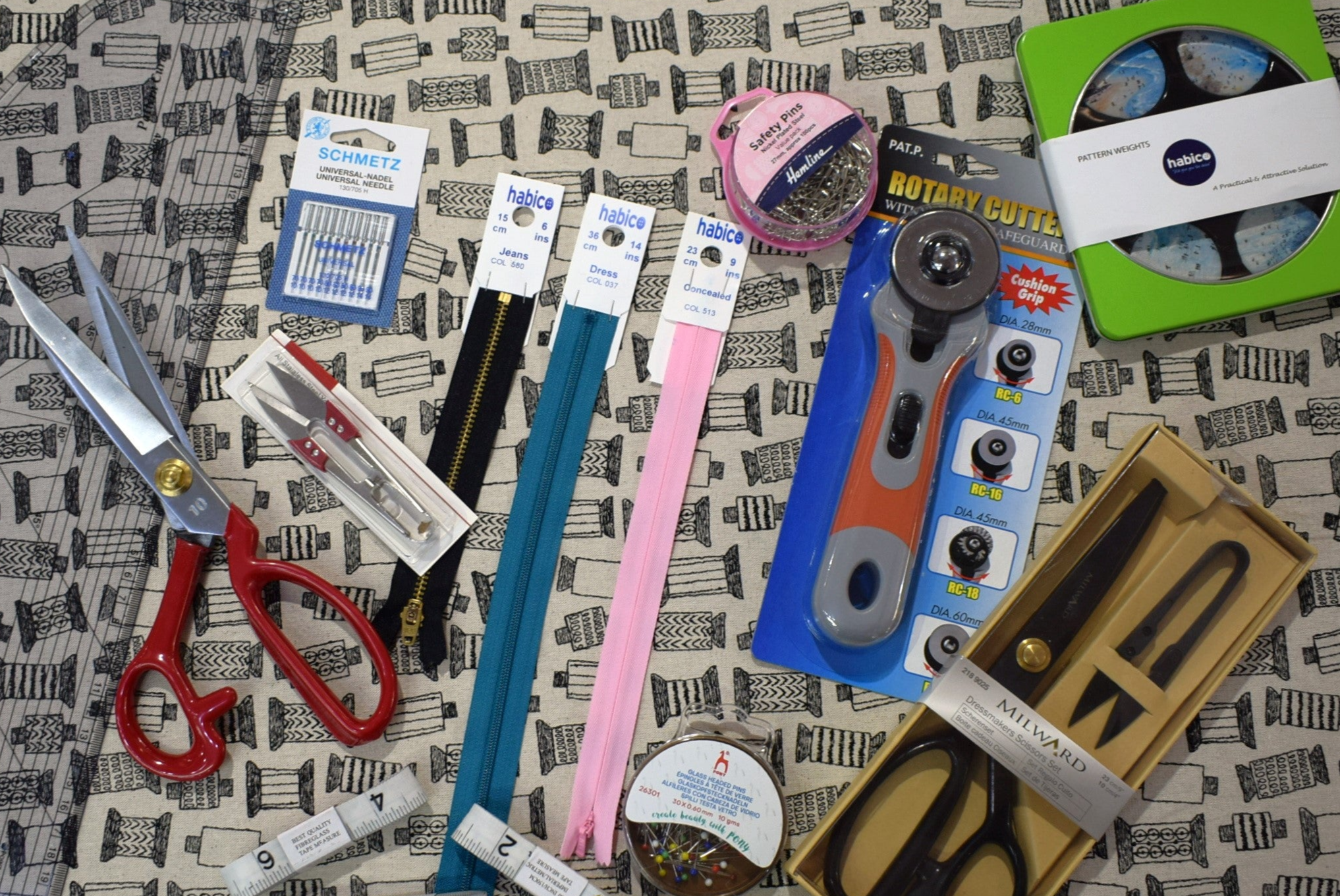 A range of haberdashery items such as scissors, zips and pins.